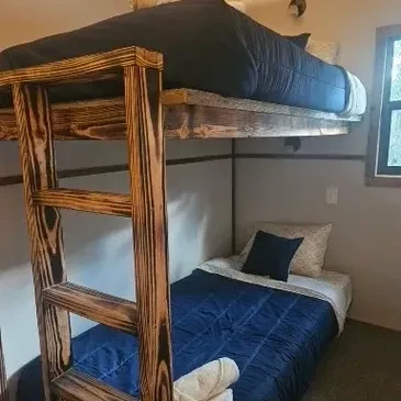 Bunk room with wooden bunk beds and blue bedding