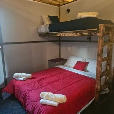 Queen room with queen bed and bunk bed, red bedding